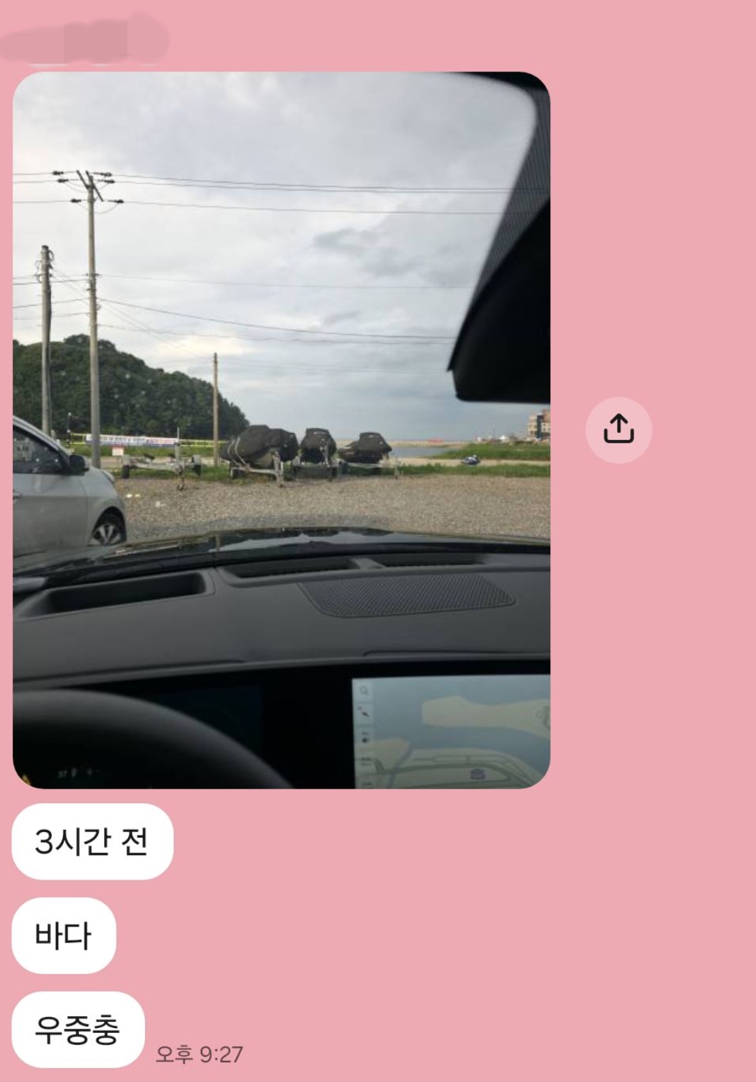 흐린 날 차 안에서 앞유리 너머로 촬영한 해변과 수상레저 장비 보관 구역